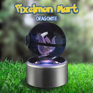 Peut inclure: Une figurine Dragonite transparente et sphérique à l'intérieur d'une sphère sombre, reposant sur une base argentée. La figurine est de couleur violet clair. Le texte "Pixelmon Mart" et "Dragonite" sont affichés au-dessus de la sphère.