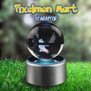 Pode incluir: Um objeto esférico transparente com um design Starly, repousando sobre uma base prateada. O objeto tem um interior escuro com uma imagem de Starly e o texto "STARAPTOR" acima. O fundo é verde desfocado.