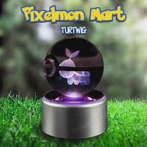 May include: A silver base with a purple glowing light supports a clear sphere with a Turtwig design. The sphere has a black band and a clear lens. The text "Pixelmon Mart" and "Turtwig" are displayed above the sphere.