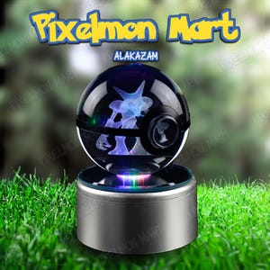 May include: A glowing crystal ball with a Pokemon design, resting on a silver base. The ball features a detailed interior image of a Pokemon character, illuminated with blue and white light. The text "Pixelmon Mart" and "Alakazam" are visible.