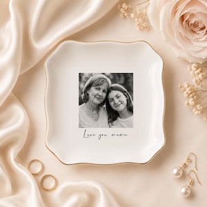 May include: A white ceramic trinket dish with a gold rim, featuring a black and white photo of a mother and daughter. The dish is inscribed with the words "Love you, mama."