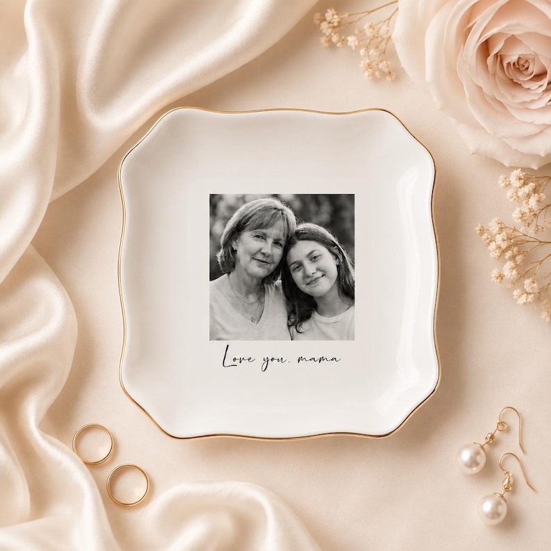 May include: A white ceramic trinket dish with a gold rim, featuring a black and white photo of a mother and daughter. The dish is inscribed with the words "Love you, mama."
