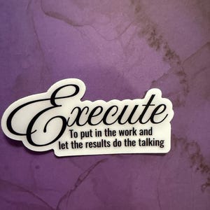 May include: A white sticker with the word "Execute" in a cursive font. Below the word is the phrase "To put in the work and let the results do the talking" in a black, sans-serif font. The sticker is on a purple background.
