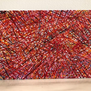 May include: Abstract painting on canvas with a dense network of red lines over a multicolored background. The artwork features a chaotic yet visually engaging composition, with a mix of red, black, and hints of other colors.
