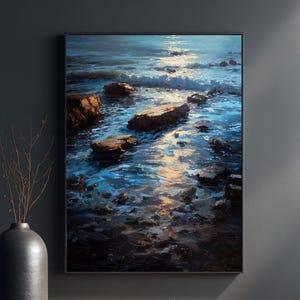 May include: A framed art print depicting a seascape with rocks in the water. The artwork features shades of blue and brown, with light reflecting on the water's surface. The print is displayed on a dark gray wall, with a vase and decorative branches in the foreground. The text "BLUESHELL PRINTS" is at the bottom.