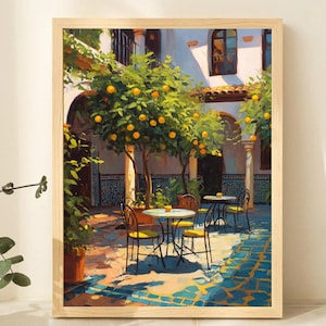 May include: A framed art print depicts a sunlit courtyard scene. The artwork features orange trees, bistro tables, and chairs, with a blue and yellow tiled floor. The building has arched doorways and windows, creating a warm, inviting atmosphere.