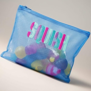 May include: A rectangular blue mesh zipper pouch featuring the word SQUISH printed in large, multi-colored letters across the front. The translucent material reveals colorful, rounded objects stored inside the bag, which has a blue zipper closure.