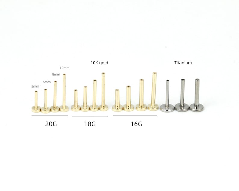 May include: A collection of gold and silver body jewelry studs. The studs are labeled with sizes and gauges, including 20G, 18G, and 16G. The gold studs are marked as 10K gold, and the silver studs are labeled as titanium.