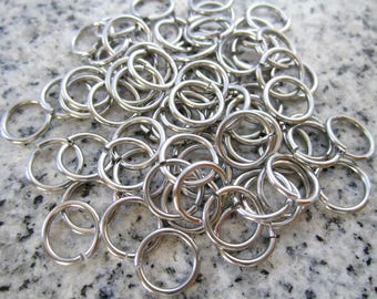 Puede incluir: Un montón de anillos de salto plateados, un tipo de anillo de metal utilizado para la fabricación de joyas y la artesanía.