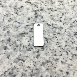May include: A blank, silver, rectangular tag with a hole at the top.