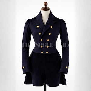 May include: A navy blue double-breasted jacket with gold-colored buttons. The jacket has long sleeves and a tailored fit, displayed on a mannequin. The text "THE NOBLE TAILOR" is visible on the jacket.