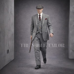 May include: A three-piece gray tweed suit with a matching flat cap, burgundy tie, and pocket square. The suit includes a vest and a tailored jacket. The image also shows a walking stick and the text "THE NOBLE TAILOR".