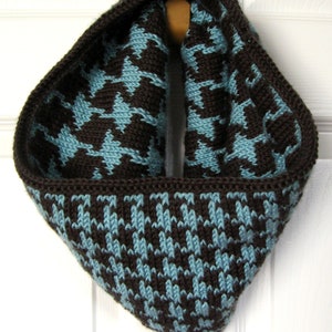 May include: A brown and blue crocheted infinity scarf with a houndstooth pattern.