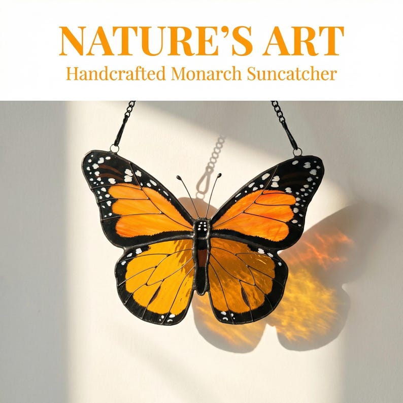 K&ouml;nnte beinhalten: Ein handgefertigter Monarchfalter-Sonnenf&auml;nger mit orangefarbenen und schwarzen Fl&uuml;geln, wei&szlig;en Punkten und einem schwarzen Rand. Der Text "NATURE'S ART Handcrafted Monarch Suncatcher" steht oben. Der Sonnenf&auml;nger h&auml;ngt an einer Kette.