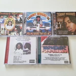 Peut inclure: Collection de cinq albums CD de Tommy Wright III. Les pochettes des albums présentent des images de l'artiste, des titres d'albums et des avertissements aux parents. Les CD sont dans des boîtiers en plastique transparent, avec diverses couleurs et graphismes.