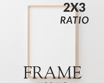 May include: A light-colored wooden frame mockup with a white interior, set against a white background. The text "2X3 RATIO" is at the top, and "FRAME MOCKUP" is at the bottom, both in black, sans-serif font. The frame is empty.