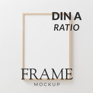 May include: A rectangular wooden frame mockup with the text "DINA RATIO" and "FRAME MOCKUP" in black. The frame is empty, with a white background.