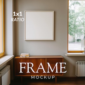 Può includere: Una cornice quadrata bianca appesa a una parete grigio chiaro sopra una credenza in legno. Il testo 1x1 RATIO e FRAME MOCKUP è visibile in lettere bianche. La cornice è vuota e presenta un bordo sottile di colore chiaro.