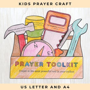 Op de afbeelding: Een papieren knutselwerk getiteld PRAYER TOOLKIT met een bruine gereedschapskist gevuld met gekleurde papieren uitsparingen van een hamer, zaklamp, zaag, kompas en moersleutel. De tekst op de doos luidt Prayer is the most powerful tool in your toolbox.