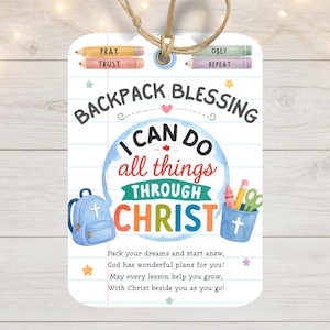 Pode incluir: Uma etiqueta retangular com cantos arredondados e um cordão, com um fundo de papel pautado. Exibe o texto "BACKPACK BLESSING" e "I CAN DO all things THROUGH CHRIST" com ilustrações de uma mochila azul, lápis e um copo.