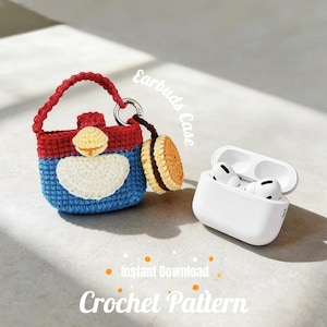 May include: A handmade crochet earbud case in red, blue, and white, with a matching charm. The case is shaped like a small bag with a handle. Next to it is a white earbud case with earbuds inside. The words "Earbuds Case" and "Crochet Pattern" are visible.