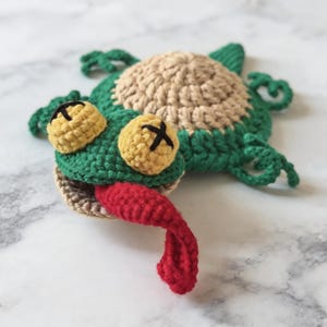 amigurumi lizard coaster crochet pattern close up, textured crochet reptile mug rug design