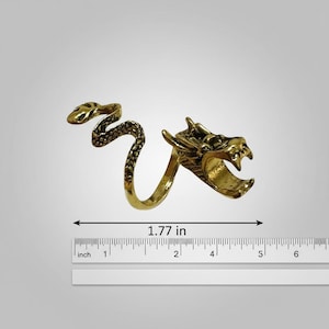 May include: A gold-colored dragon ring. The ring features a dragon head and a snake design, with a total length of 1.77 inches. The ring is made of metal and has intricate details.