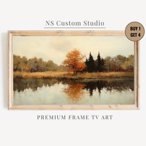 May include: A landscape painting in a light wood frame depicting a calm lake reflecting a forest with a prominent orange tree and dark evergreens under a pale sky. Text reads NS Custom Studio and BUY 1 GET 4 PREMIUM FRAME TV ART.