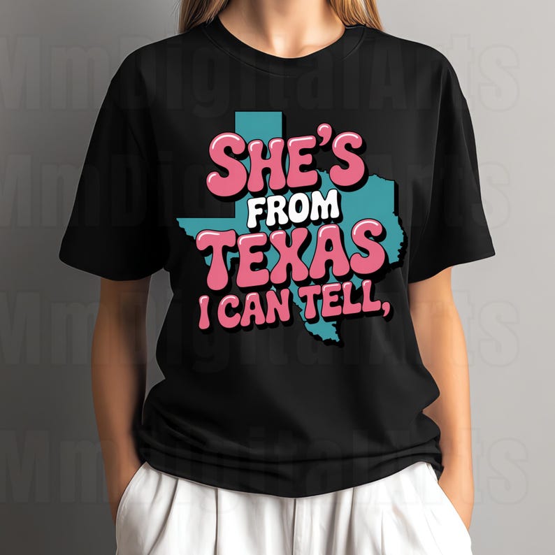 May include: Black t-shirt featuring the text "She's From Texas I Can Tell," in pink and white, with a teal Texas outline. The shirt has short sleeves.