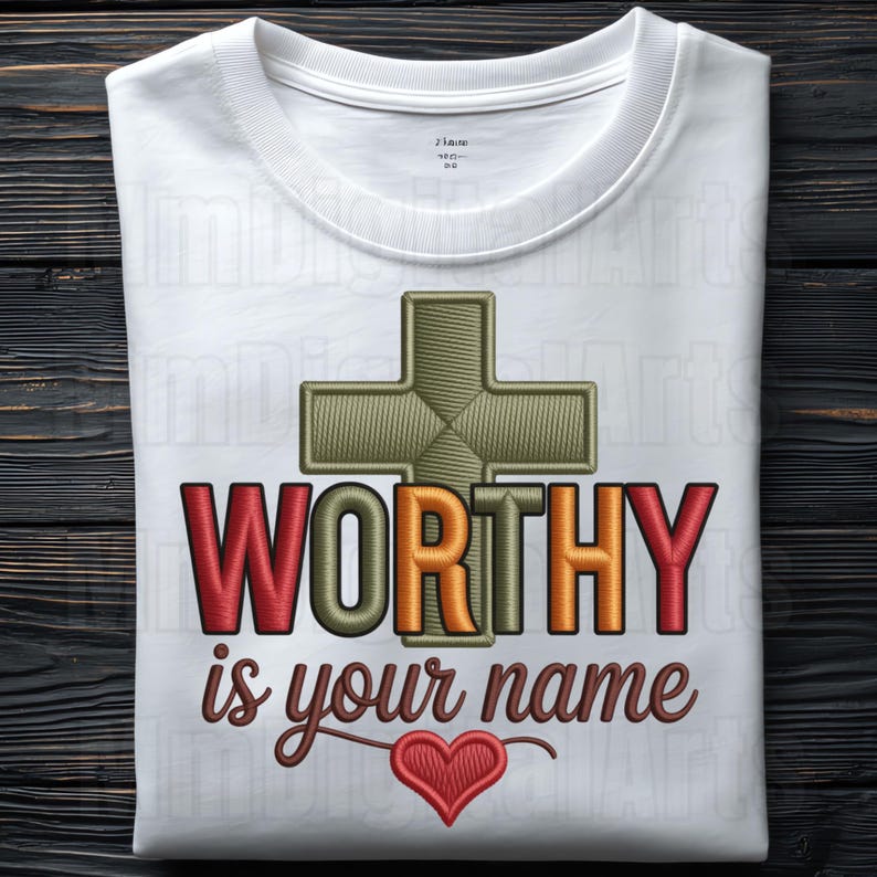 May include: White crew neck t-shirt with the embroidered text "WORTHY is your name" in red, orange, and brown. A green cross and a red heart are also embroidered on the shirt. The shirt is made of a soft, comfortable material.