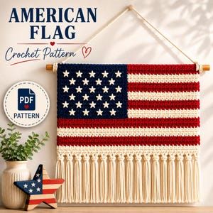 Op de afbeelding: Een gehaakte wandhanger met het ontwerp van de Amerikaanse vlag, uitgevoerd in rood, wit en blauw garen met witte sterren en crèmekleurige franjes aan de onderkant. De tekst luidt AMERICAN FLAG Crochet Pattern en PDF PATTERN. Een houten stok draagt het.