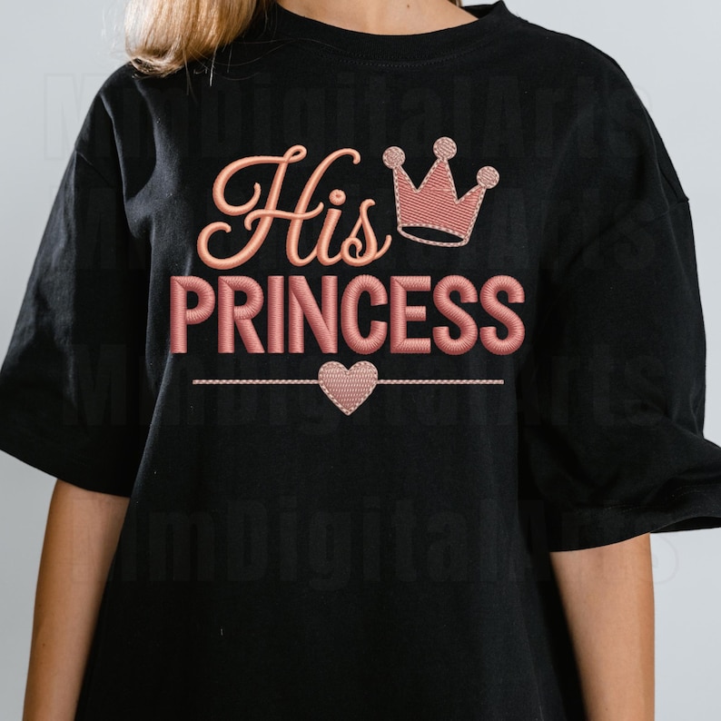 May include: Black t-shirt with the embroidered text "His Princess" in a pink script font. A pink crown and heart are also embroidered on the shirt, creating a romantic theme.