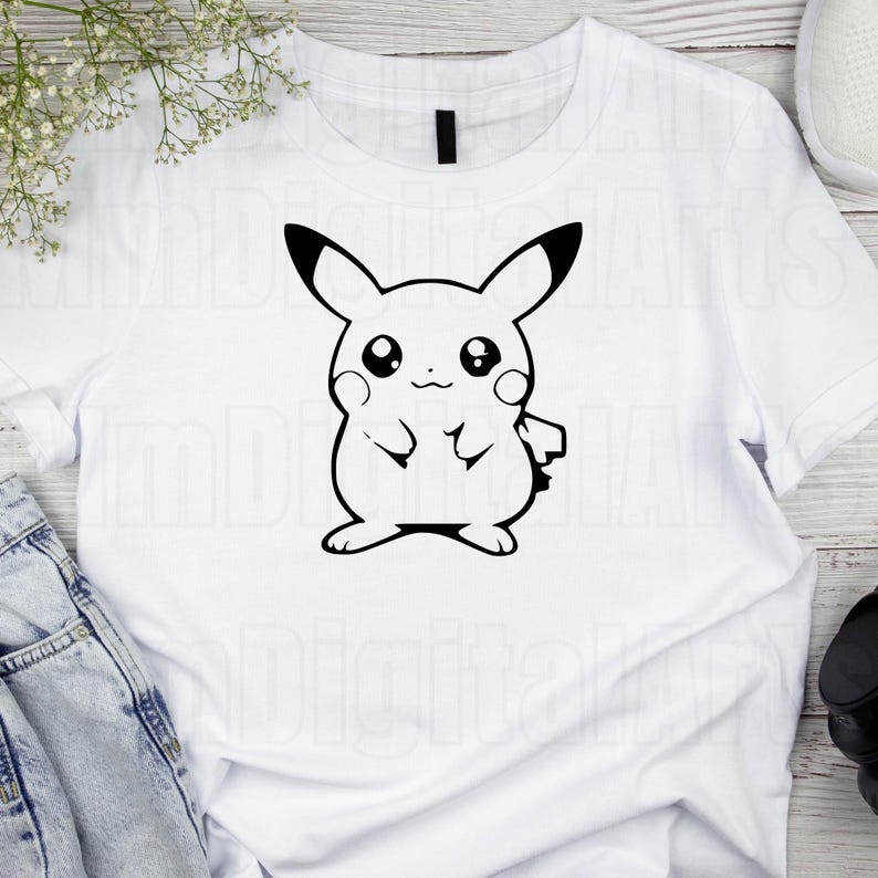 May include: White t-shirt featuring a black outline of Pikachu, a popular character. The design shows Pikachu with its arms at its sides, and its ears are black-tipped. The shirt is made of a soft material and is suitable for casual wear.