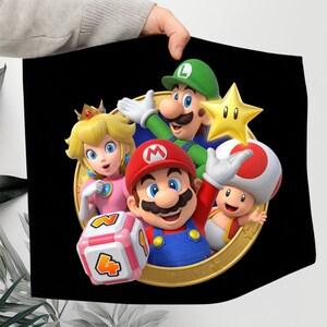 May include: A black square featuring a colorful illustration of Mario, Luigi, Princess Peach, Toad, and a star. Mario is wearing a red hat and overalls, and Luigi is in green. The characters are set against a gold circular frame.