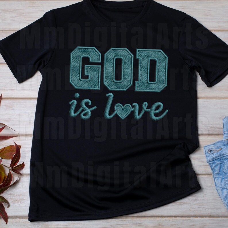 May include: Black t-shirt with the teal text "GOD is love" in a script font. The word "GOD" is in a block letter style. A heart symbol replaces the "o" in "love".