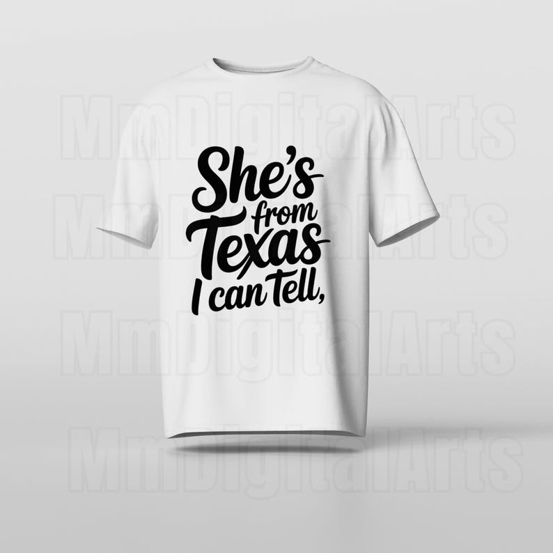 May include: A white t-shirt featuring the black text "She's from Texas I can Tell," in a cursive font. The shirt has a crew neck and is suitable for everyday wear. The text is centrally placed on the front of the garment.