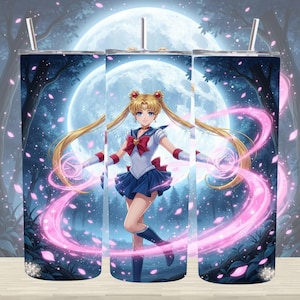 May include: A tumbler featuring a Sailor Moon anime design. The artwork depicts the character in a blue and white sailor uniform with a red bow, set against a backdrop of a full moon, trees, and pink energy effects. Includes a straw.