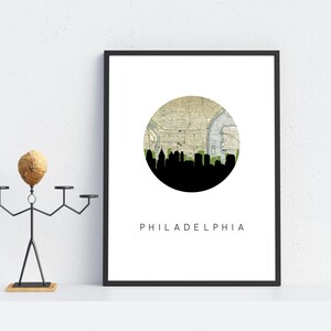 Philadelphia Pennsylvania city wall art featuring the Philadelphia skyline and a Philadelphia city map. Available in several cities and frame options. Philadelphia Pennsylvania shown in a black frame. Designed by www.etsy.com/shop/paperfinchdesign