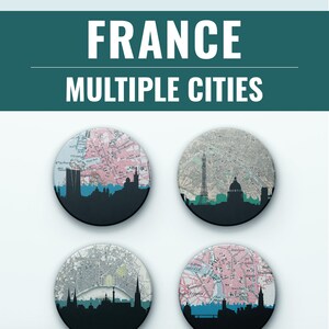 May include: Four round coasters featuring city skylines and vintage map designs. Each coaster has a black silhouette of a city skyline at the bottom, with a map design above. The text "FRANCE MULTIPLE CITIES" is at the top.