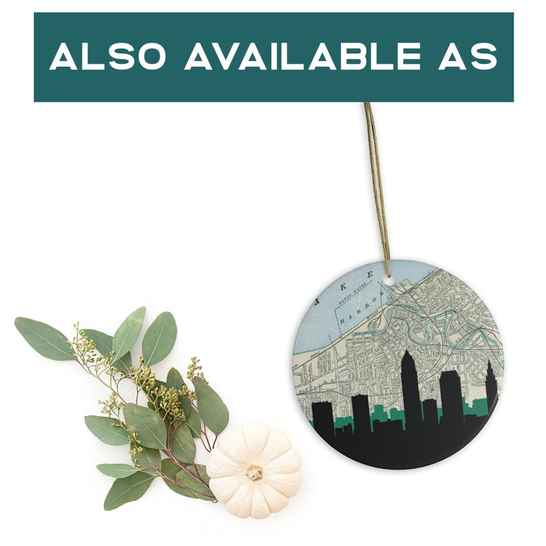 May include: A round ceramic ornament featuring a map design with a black skyline silhouette. The ornament has a gold string for hanging. The text "ALSO AVAILABLE AS" is at the top of the image.