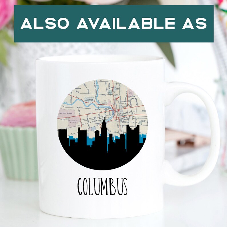 May include: White ceramic mug featuring a black silhouette of a city skyline with a map design in the center. The word "COLUMBUS" is printed in a handwritten font below the design. The text "ALSO AVAILABLE AS" is at the top.