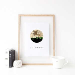Columbus Indiana art print featuring the Columbus Indiana skyline and a Columbus Indiana city map. Available in several cities and frame options. Columbus Indiana shown in a brown frame. Designed by www.etsy.com/shop/paperfinchdesign