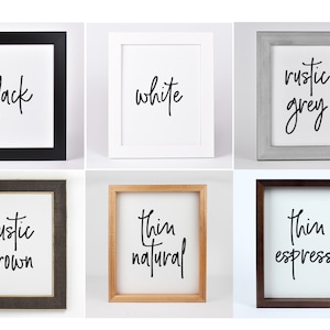May include: A collection of framed art prints, each featuring a white background with a word in black script. The frames are in various colors: black, white, rustic grey, rustic brown, thin natural, and thin espresso.