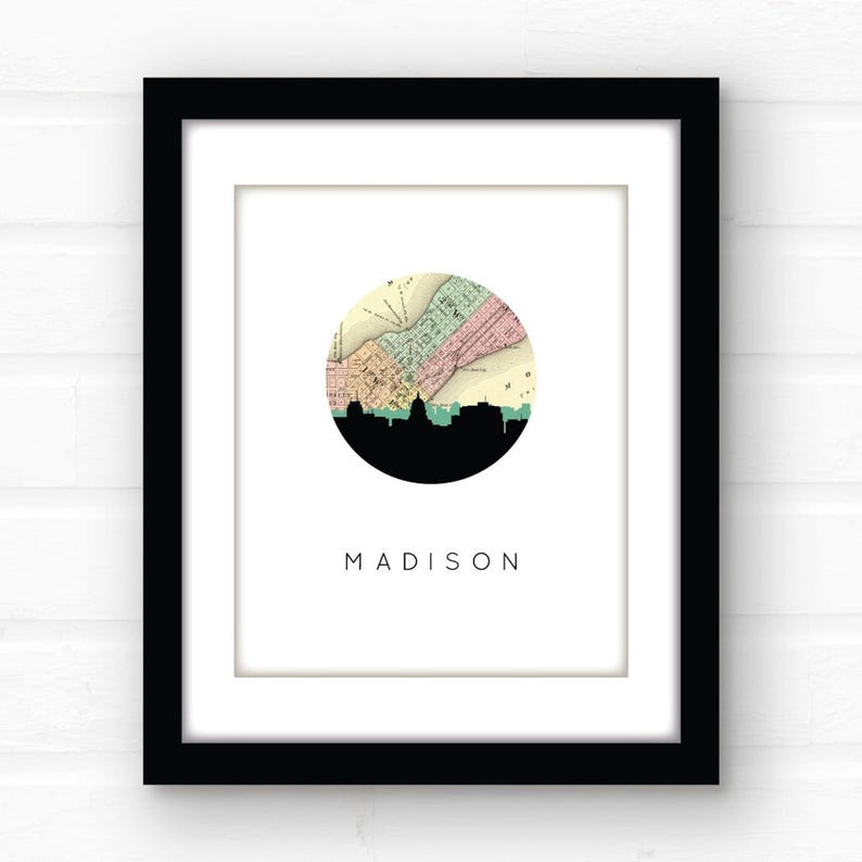 A framed Madison map print hangs against a white brick wall.