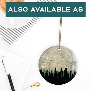 Flatlay view of a round ceramic ornament hanging by a gold string, with a notebook, pen, and coffee cup nearby.