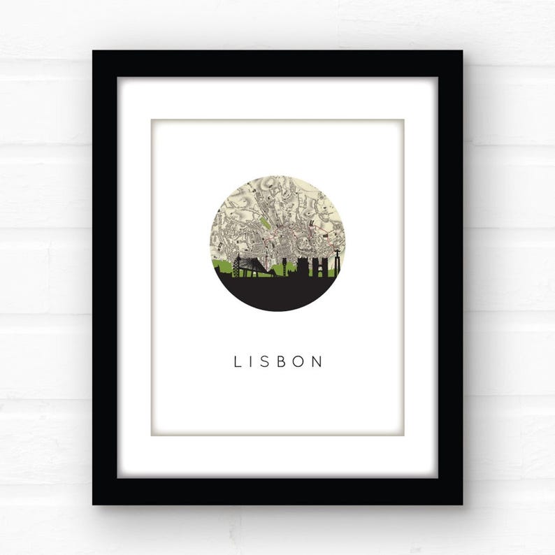 Close-up of a framed Lisbon print with a white mat against a white brick wall.