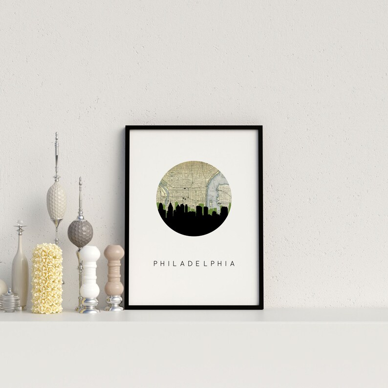 Philadelphia Pennsylvania city wall art featuring the Philadelphia skyline and a Philadelphia city map. Available in several cities and frame options. Philadelphia Pennsylvania shown in a black frame. Designed by www.etsy.com/shop/paperfinchdesign