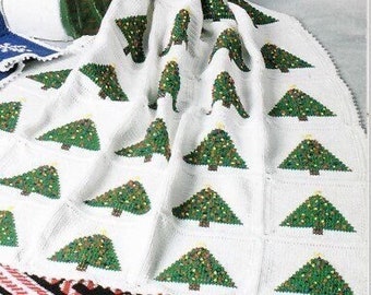 May include: A white crocheted blanket with a green and white Christmas tree pattern. A snowman figurine is in the background.