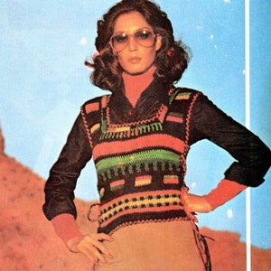 May include: A vintage fashion image featuring a woman wearing a black long-sleeved shirt with a crochet vest. The vest has a colorful striped pattern in orange, green, and black. She is also wearing tan pants and sunglasses.
