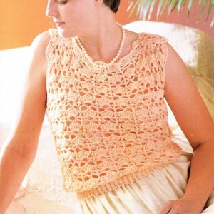 May include: A crocheted sleeveless top in a peach color with a scalloped neckline. The top is made with a delicate open stitch pattern.